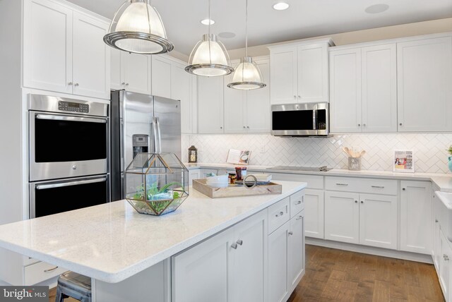 126 Green Forest Dr Unit 5Houston, Middletown, DE 19709 - kitchen featuring backsplash, a center island, light stone counters, stainless steel appliances, and white cabinetry