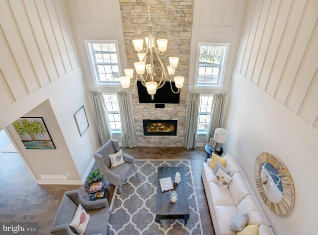 126 Green Forest Dr Unit 5Houston, Middletown, DE 19709 - living area with a high ceiling, a chandelier, a stone fireplace, baseboards, and wood finished floors