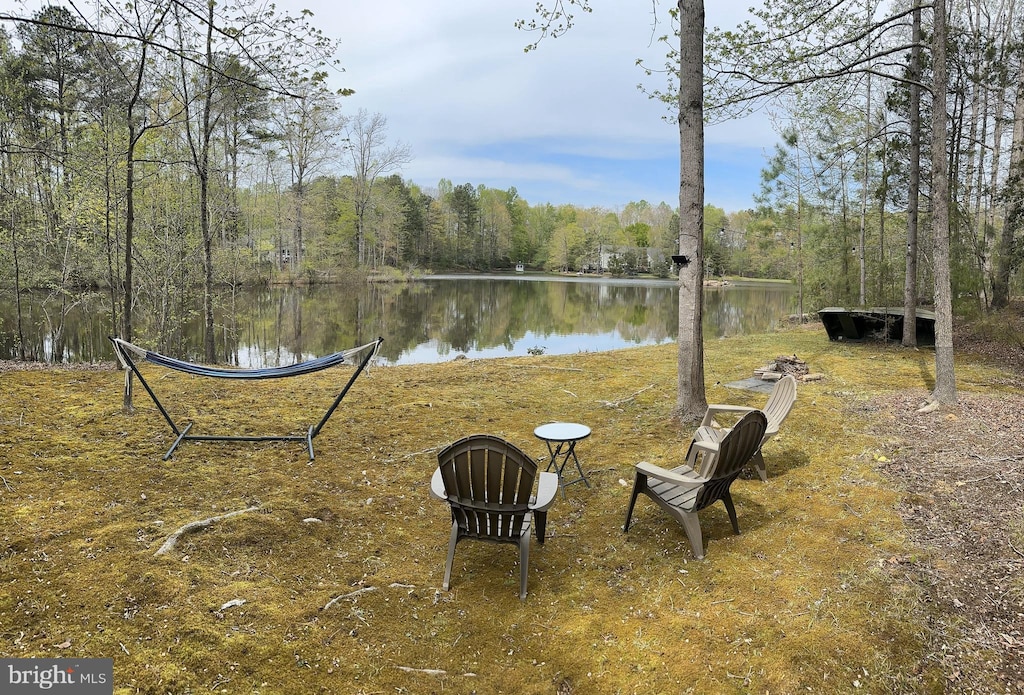 view of yard with a water view and a wooded view