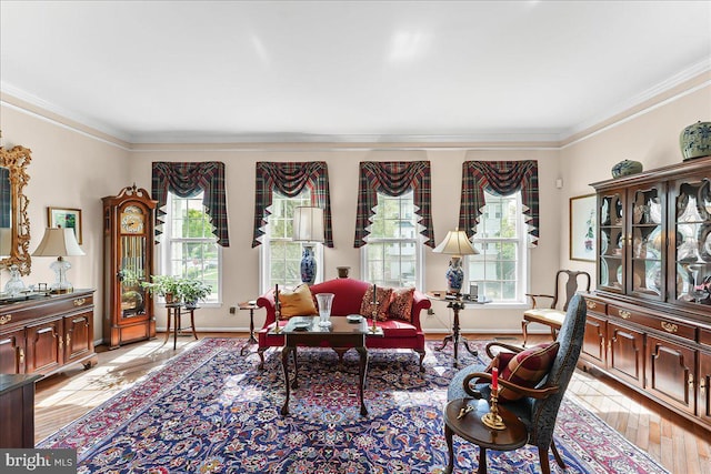 living room with light wood-style floors, ornamental molding, and baseboards