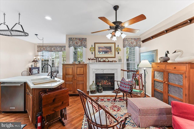 living area featuring recessed lighting, ceiling fan, light wood-style flooring, and a fireplace