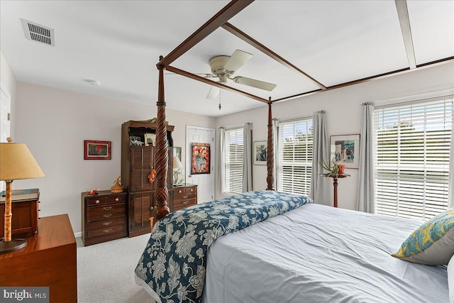 carpeted bedroom with a ceiling fan and visible vents