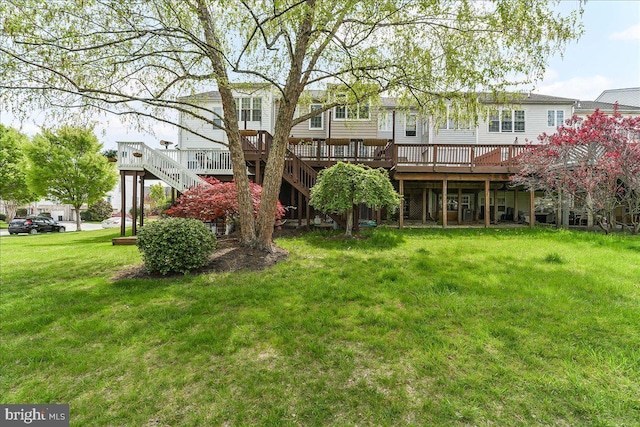 back of property featuring a lawn, a deck, and stairway