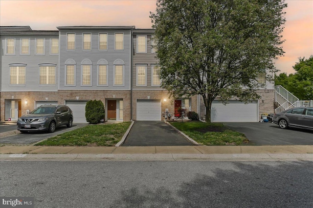 townhome / multi-family property with driveway and a garage