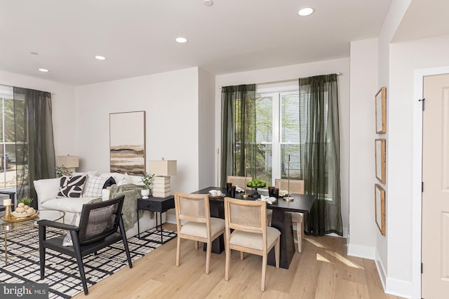 dining room featuring baseboards, light wood finished floors, and recessed lighting