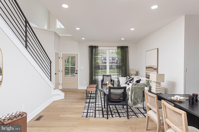living room with light wood finished floors, baseboards, visible vents, recessed lighting, and stairs