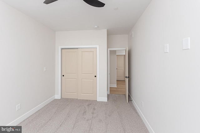 unfurnished bedroom featuring carpet floors, a closet, a ceiling fan, and baseboards