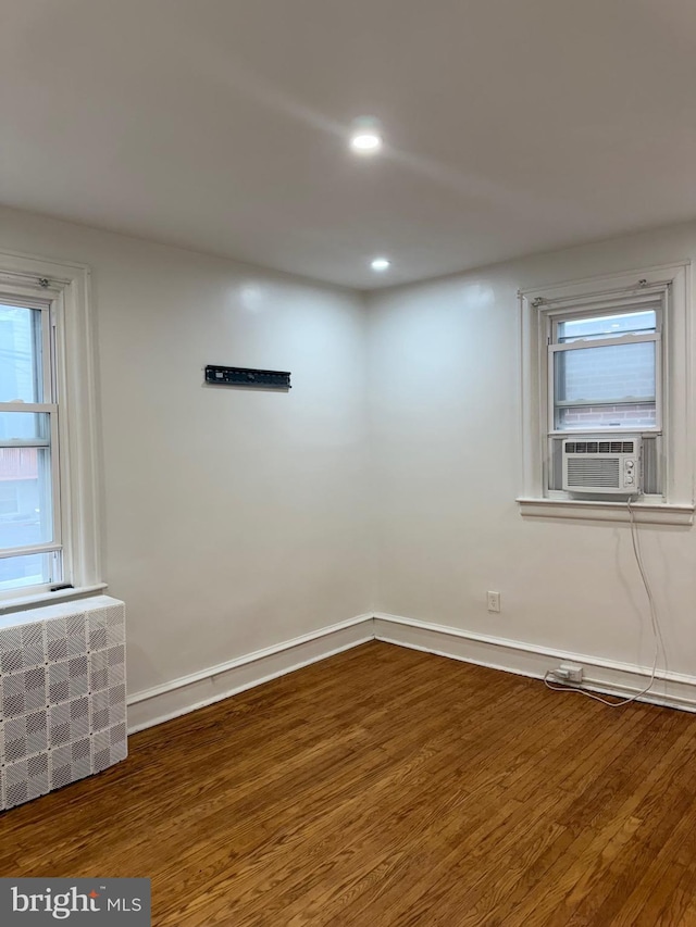 spare room with wood finished floors, cooling unit, recessed lighting, and baseboards