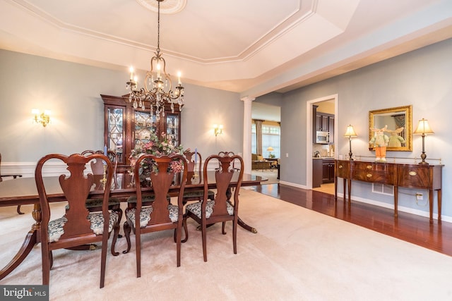 106 Mahogany Way, Upper Gwynedd, PA 19446 - carpeted dining area featuring a notable chandelier, wood finished floors, a raised ceiling, ornamental molding, and ornate columns