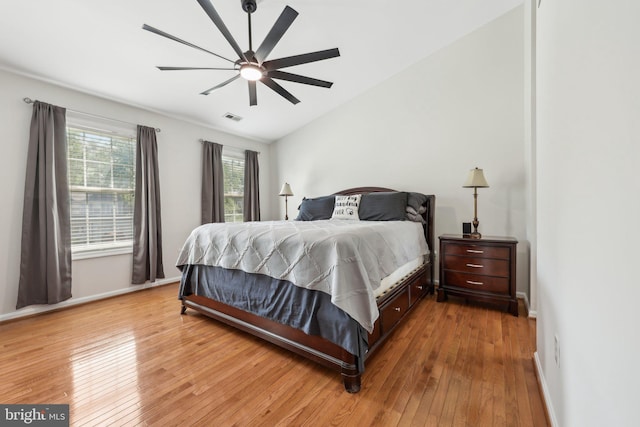 bedroom with visible vents, baseboards, lofted ceiling, and light wood-type flooring