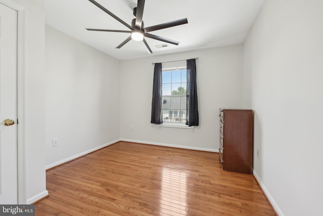 spare room featuring ceiling fan, visible vents, baseboards, and light wood-style floors