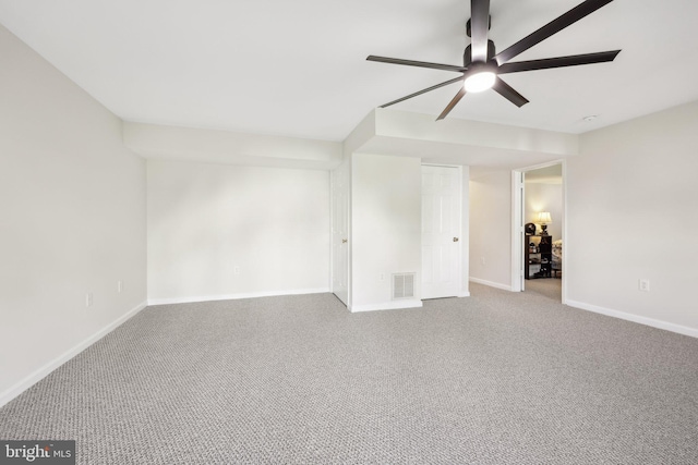 empty room with baseboards, ceiling fan, carpet flooring, and visible vents