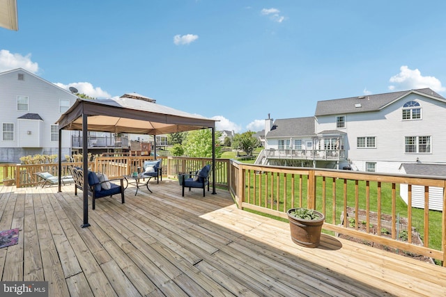 wooden terrace featuring a lawn, a gazebo, and a residential view