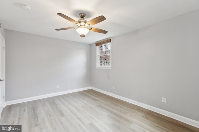 unfurnished room featuring light wood finished floors, baseboards, and a ceiling fan