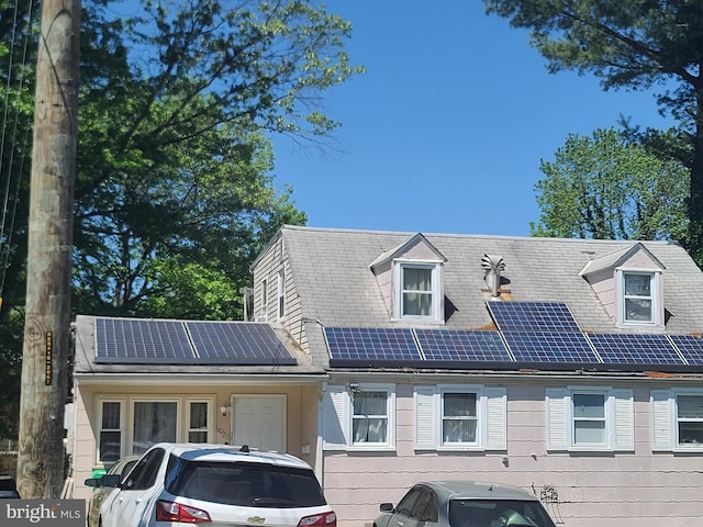 view of front facade featuring roof mounted solar panels