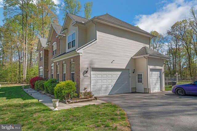 14165 Shelwick Pl, Hughesville, MD 20637 - view of side of property with an attached garage, a lawn, driveway, and fence