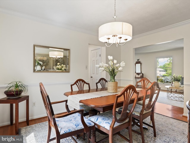 dining space featuring a chandelier, crown molding, and light wood finished floors
