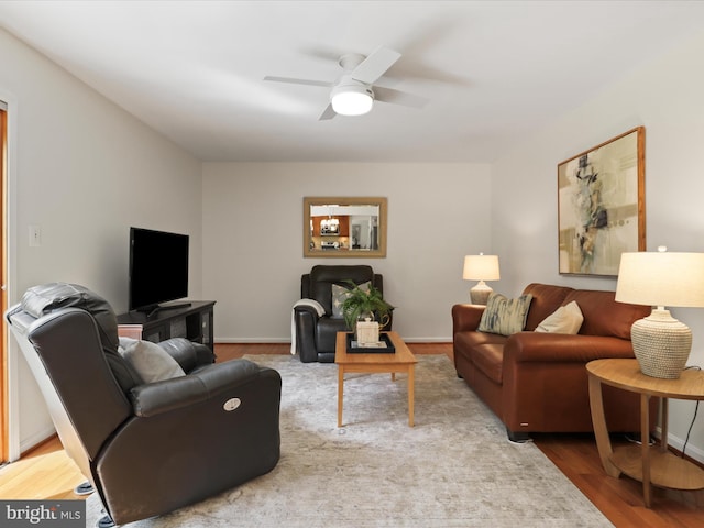 living room featuring a ceiling fan, wood finished floors, and baseboards