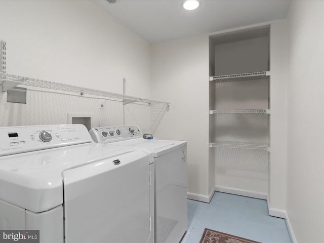 clothes washing area with washer and dryer, laundry area, and baseboards