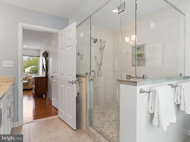 bathroom featuring tile patterned flooring, a shower stall, and vanity