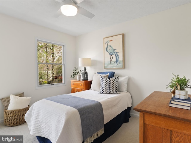 bedroom featuring a ceiling fan, light carpet, and baseboards