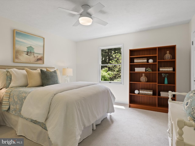 bedroom with a ceiling fan and light colored carpet