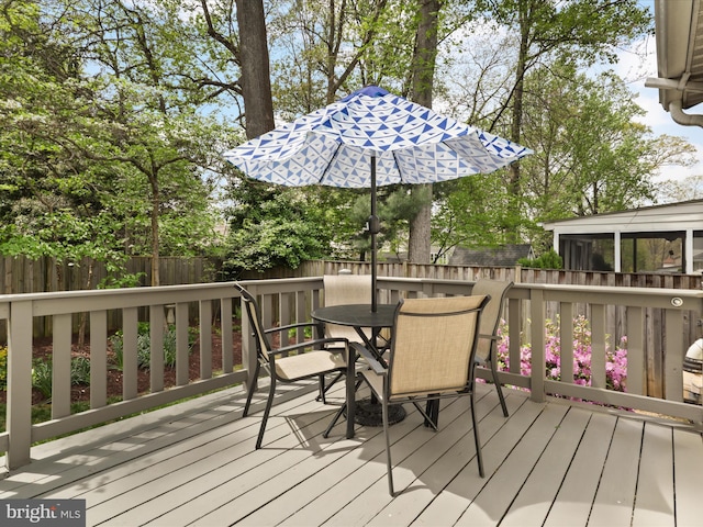 wooden terrace with outdoor dining area and a fenced backyard