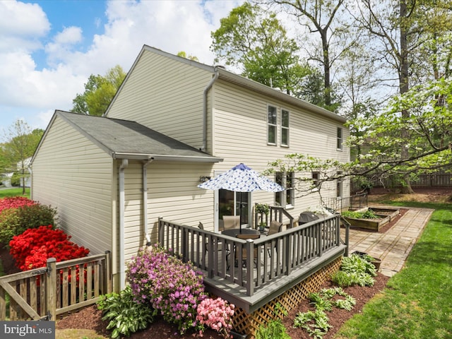 rear view of property featuring a deck and fence