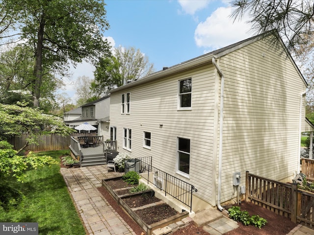back of property featuring fence, a vegetable garden, and a wooden deck