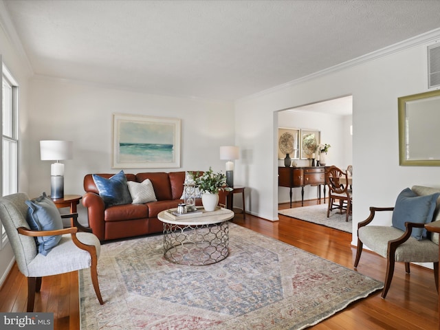 living room featuring crown molding, a wealth of natural light, and wood finished floors