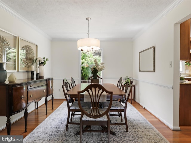 dining area featuring crown molding, an inviting chandelier, wood finished floors, and a healthy amount of sunlight