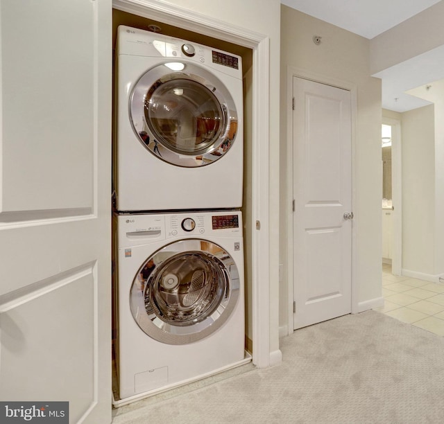 851 N Glebe Rd Unit 321, Arlington, VA 22203 - laundry room with light tile patterned flooring, laundry area, light colored carpet, baseboards, and stacked washer / dryer