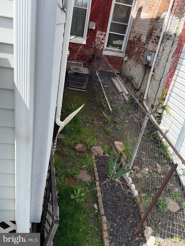 exterior details with electric meter, brick siding, and central air condition unit
