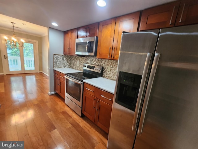 14306 Bowsprit Ln Unit 22, Laurel, MD 20707 - kitchen featuring appliances with stainless steel finishes, brown cabinets, light countertops, tasteful backsplash, and crown molding
