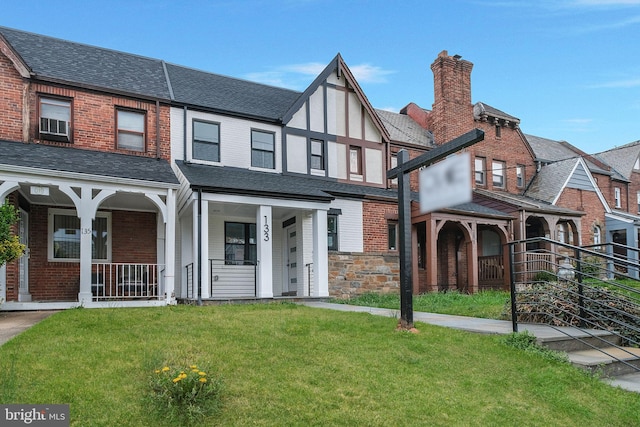 133 Ingraham St NW, Washington, DC 20011 - tudor house with a chimney, covered porch, a front lawn, and brick siding