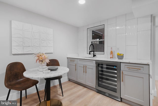133 Ingraham St NW, Washington, DC 20011 - bar with baseboards, a sink, wet bar, light wood-style floors, and wine cooler