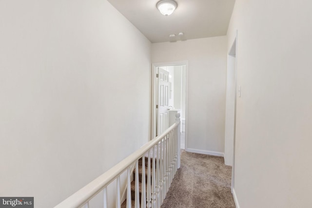 hallway with light colored carpet and baseboards