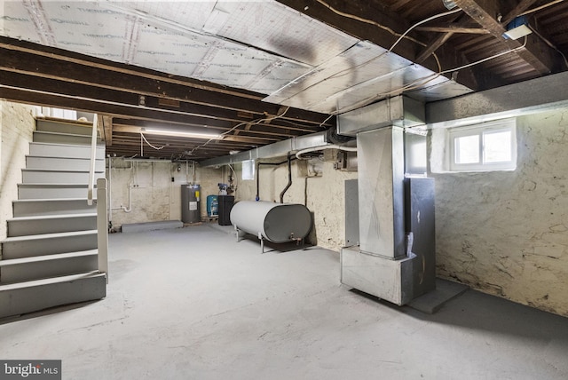 below grade area featuring water heater, stairs, heating fuel, and heating unit