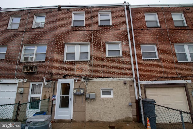 7834 Fayette St, Philadelphia, PA 19150 - rear view of house featuring brick siding, fence, cooling unit, and a garage