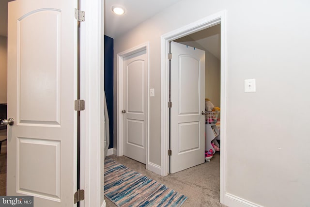 hallway with baseboards and carpet