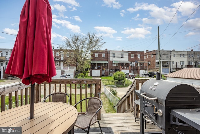 wooden terrace featuring area for grilling, a residential view, and outdoor dining space