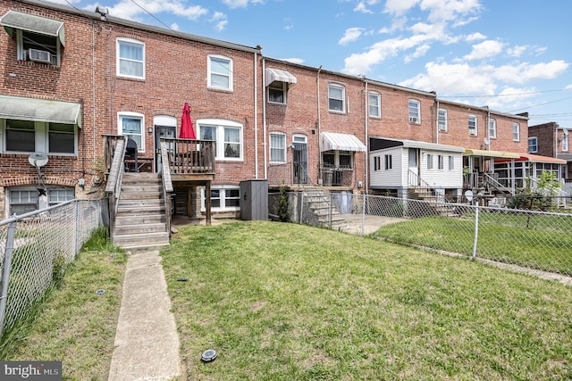 back of house with fence, cooling unit, stairs, brick siding, and a lawn