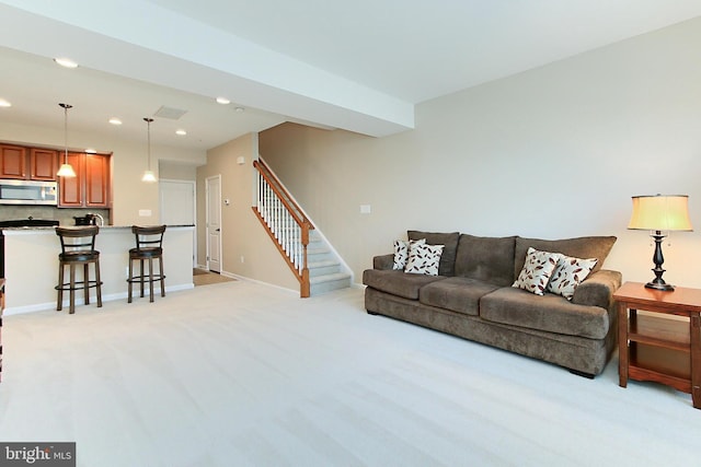 living area with recessed lighting, baseboards, stairs, and light colored carpet