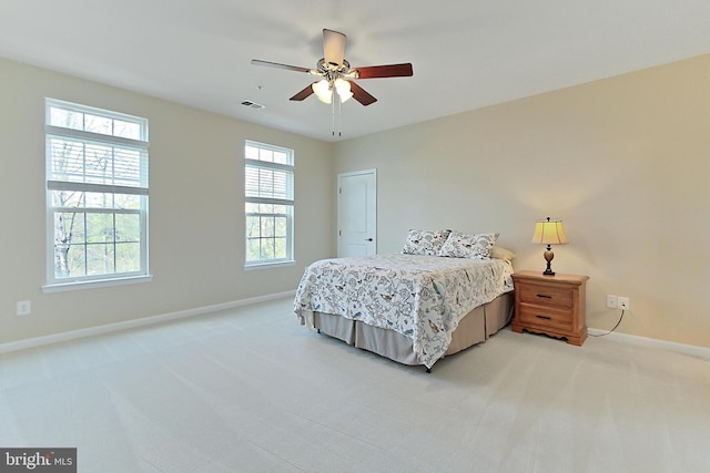 bedroom with light colored carpet, baseboards, a ceiling fan, and visible vents