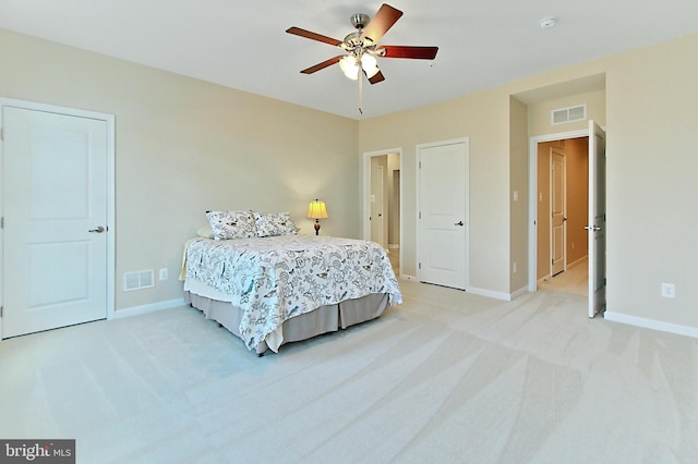bedroom with baseboards, a ceiling fan, visible vents, and light colored carpet