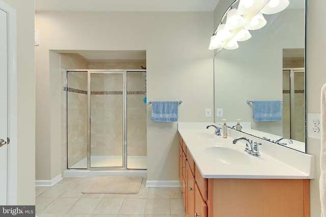 bathroom with tile patterned flooring, baseboards, a sink, and a stall shower