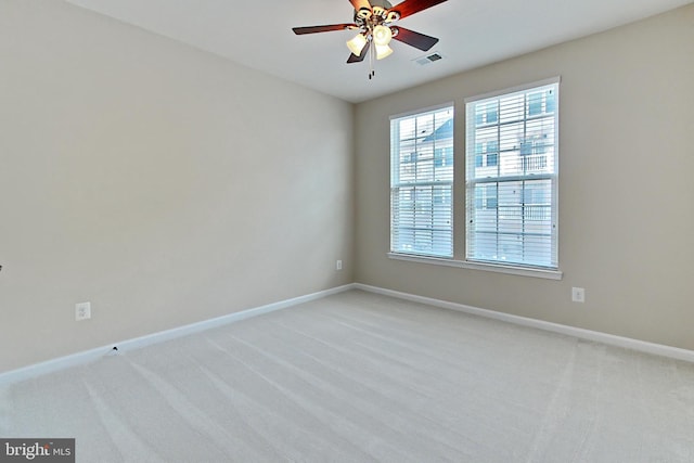 empty room featuring ceiling fan, light carpet, visible vents, and baseboards