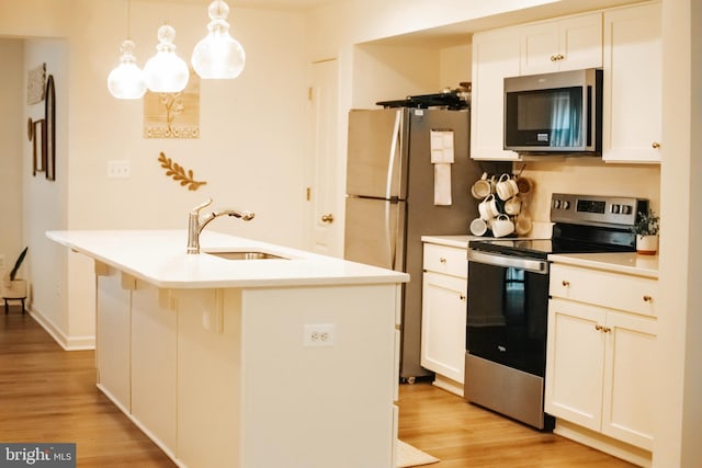 172 Scotch Pine Dr, Bunker Hill, WV 25413 - kitchen with a sink, light wood-style flooring, light countertops, white cabinets, and appliances with stainless steel finishes