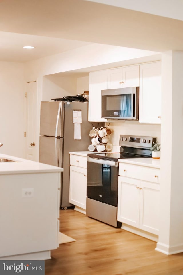 172 Scotch Pine Dr, Bunker Hill, WV 25413 - kitchen featuring light wood-style floors, stainless steel appliances, and white cabinets