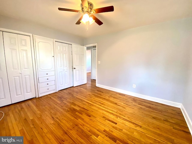 8107 Candle Ln, Baltimore, MD 21237 - unfurnished bedroom featuring wood-type flooring, two closets, a ceiling fan, and baseboards